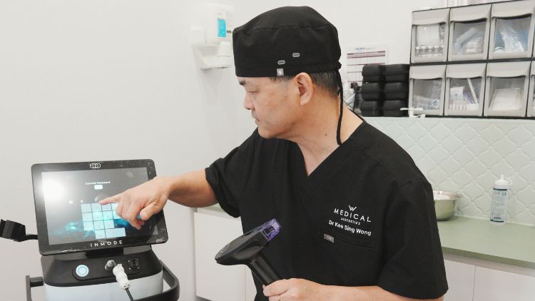 Dr Wong explaining an RF microneedling device